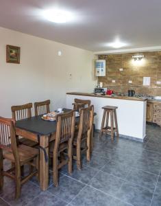 Un comedor con mesa y sillas y una cocina. en Altos la Villa, en San Rafael