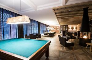 a pool table in a room with tables and chairs at Vayamundo Houffalize in Houffalize