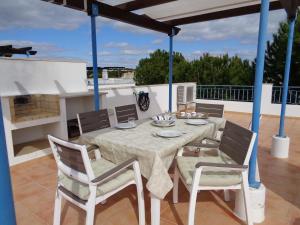 a dining table and chairs on a patio at Farol da Cortesia - Praia Verde in Praia Verde