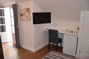 a room with a desk with a television on a wall at Edificio Charles 303 in Funchal