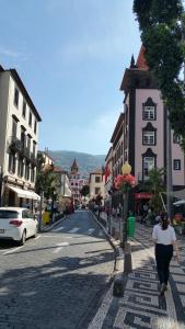 a woman walking down a street in a town at Edificio Charles 303 in Funchal