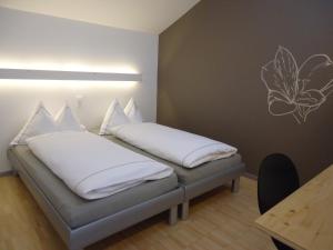 Camera con 2 letti e cuscini bianchi di Hotel Alte Gärtnerei a Härkingen
