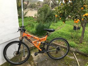 un vélo orange garé à côté d'une maison dans l'établissement Surfers' Cottage, à Anavyssos