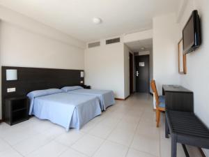 a bedroom with a bed and a flat screen tv at Hotel Safari in Gandía