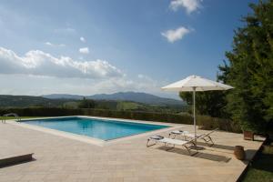 a swimming pool with an umbrella and a chair at Aurora Elegant Residence in Episkopi (Heraklion)