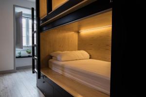 a bedroom with a bunk bed with white sheets at GiG Capsule Hostel in Ericeira