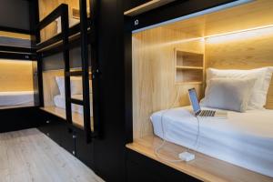 a bedroom with a bed with a laptop on it at GiG Capsule Hostel in Ericeira
