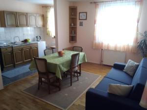 a kitchen and living room with a table and a couch at Guesthouse Pavličić in Drežnik Grad