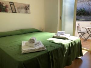 Una cama verde con toallas encima. en Central Panoramic en Taormina