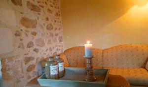 uma vela e duas garrafas numa mesa com um sofá em Cardabelle Holiday Home with private garden em Mazières