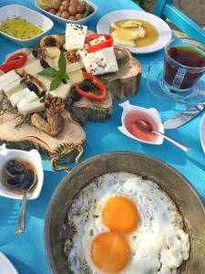 a table with a plate of eggs and other food at Dimitri Ada Evi & Restaurant in Gokceada Town