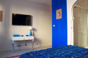 1 dormitorio con 1 cama, lavamanos y TV en Riad SPA "Les Portes de l'Orient" TOURS, en Tours