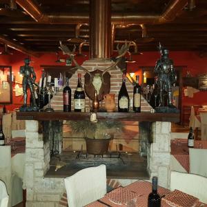 a fireplace in a restaurant with bottles of wine at Hotel Il Dito e la Luna in Ripa Teatina