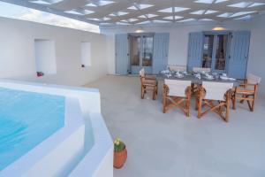 a dining room with a table and a swimming pool at Passos Villas in Parasporos