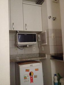 a microwave above a refrigerator in a kitchen at Studio in Copa in Rio de Janeiro