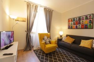 uma sala de estar com um sofá e uma cadeira amarela em La casa della nonna sulla francigena em Campagnano di Roma