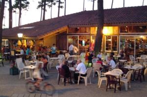 a group of people sitting at tables in a restaurant at Chalet Camping 5 étoiles Landes in Lit-et-Mixe