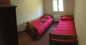 two beds in a small room with pink sheets at Villa Rafael in Vega de San Mateo
