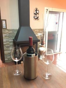 a bottle of wine in a metal container with two wine glasses at Villa Rafael in Vega de San Mateo