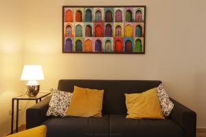 a couch in a living room with a painting on the wall at Casa della nonna sulla francigena in Campagnano di Roma