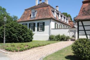 ein weißes Haus mit rotem Dach in der Unterkunft Jagdschloss Mönchbruch in Mörfelden-Walldorf