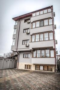 a tall white building with windows on a street at Hotel Elisabeta in Bucharest