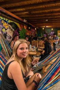 Eine Frau, die in einer Hängematte in einem Restaurant sitzt in der Unterkunft Purple Monkey Hostel in Medellín