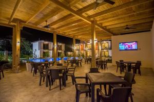 a restaurant with tables and chairs and a flat screen tv at Caribbean Diamond Boutique Hotel in Sosúa