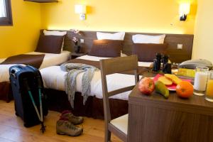 a hotel room with two beds and a table with fruits at Logis Auberge De La Dune - Hôtel & Restaurant in Le Crotoy