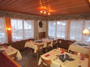 a dining room with white tables and chairs and windows at Restaurant Felsenburg in Kandergrund