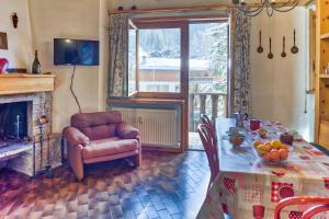 a living room with a table and a chair at The Twins Apartment - Champoluc in Champoluc