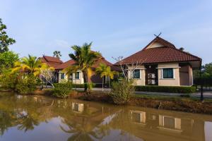 a house next to a body of water at Boom Forest Hotel in Hat Yai