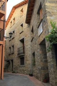 - un bâtiment en pierre avec un balcon sur le côté dans l'établissement Hostal Casa Vispe, à Escalona