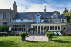 a large brick house with a large patio at Lanelay Hall Hotel & Spa in Hensol