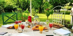 stół z talerzami jedzenia i szklanki soku pomarańczowego w obiekcie les trésors de malle mialle w mieście Le Thor