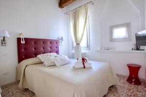 a bedroom with a large bed with a red headboard at B&B Al Pozzo di Luce in Venice