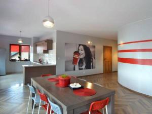 a kitchen with a table with chairs and a picture of a woman at Pokoje Staromiejski in Uniejow