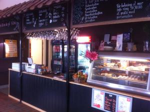 a restaurant with a counter with a display of food at Vilsta Camping and Cottages in Eskilstuna