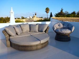 eine Couch und zwei Stühle auf einer Terrasse in der Unterkunft Villa Tara Christina in Carvoeiro