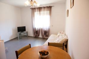 Cette chambre comprend une table, un canapé et une télévision. dans l'établissement Casa do Prado, à Vila Verde