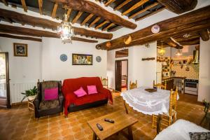 a living room with a red couch and a table at Casa el Portón in Bubión