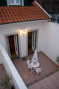 a patio with a table and an umbrella on it at Guesthouse Muralhas do Mino in Monção