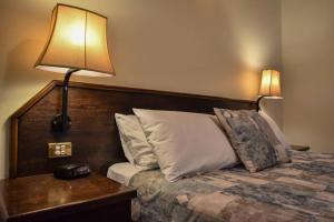 a bedroom with a bed with a lamp on a table at The Crossing Motel in Junee