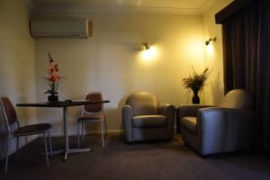 a waiting room with chairs and a table and a table and chairs at The Crossing Motel in Junee
