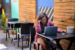 a woman sitting at a table with a laptop at 531 Hostel in Córdoba