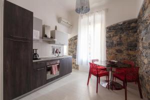a kitchen with a table and red chairs in a room at C'era Una Volta in La Spezia