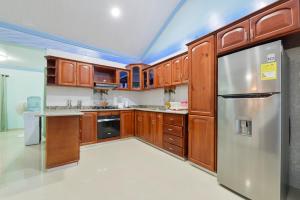 a kitchen with wooden cabinets and a stainless steel refrigerator at Posada Faych House in San Andrés