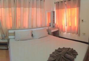 Un dormitorio con una cama blanca con almohadas blancas. en Villa Kamala Beach, en Kamala Beach