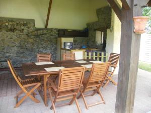 een houten tafel en stoelen op een patio bij Chambres d'Hôtes L'Ardiegeoise in Ardiège
