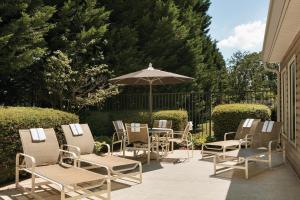 a patio area with chairs, tables and umbrellas at Country Inn & Suites by Radisson, Atlanta Airport North, GA in Atlanta